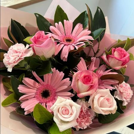 Fresh bouquet of pink gerberas, soft pink roses and carnations with green foliage, wrapped in pink paper, delivered by a Lily's Florist partner florist in Bowral NSW 