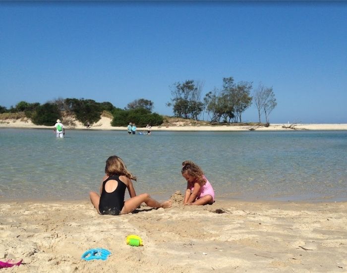 Asha and Ivy building sandcastles at the Cudgera Creek mouth, Hastings Point, 2013