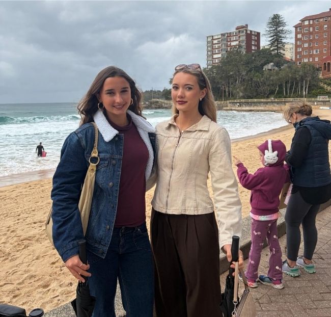 Asha and Ivy Thomson at Manly Beach with their great-grandmother's old apartment building in the background